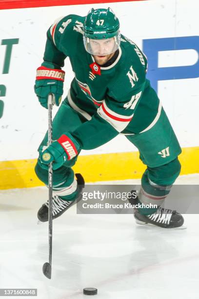Alex Goligoski of the Minnesota Wild handles the puck against the Detroit Red Wings during the game at the Xcel Energy Center on February 14, 2022 in...