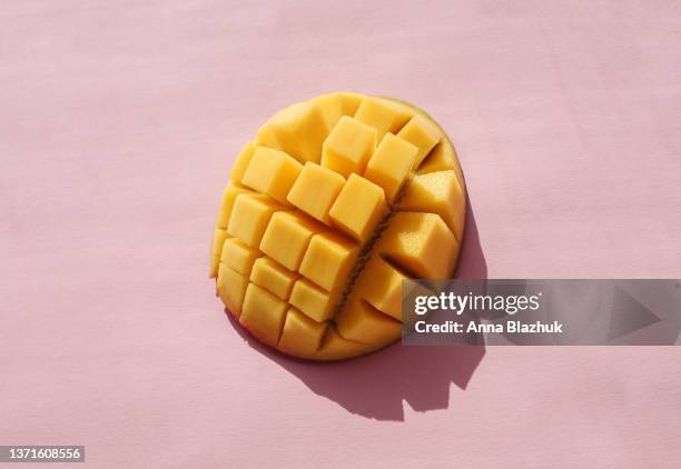 chopped mango fruit in bright sunlight over pink background - mango 個照片及圖片檔