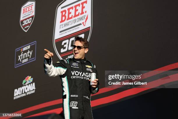 Landon Cassill, driver of the Voyager: Crypto for All Chevrolet, waves to fans onstage during the driver intros prior to the NASCAR Xfinity Series...