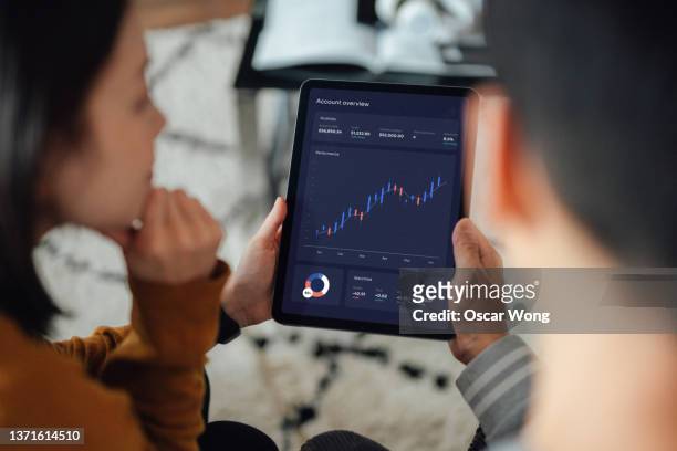 young couple making financial plans with digital tablet - cuenta de banco fotografías e imágenes de stock