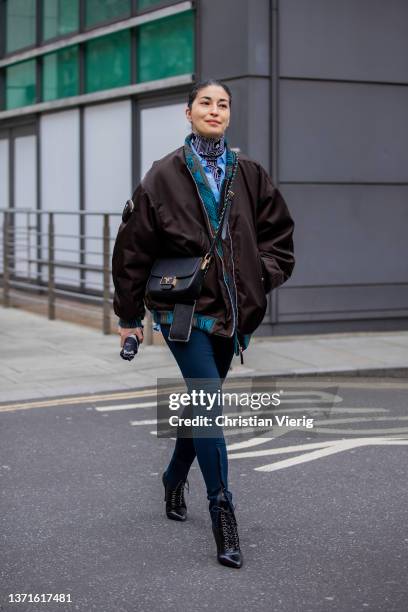 Caroline Issa seen wearing brown bomber jacket, Prada bag, Prada turtleneck, slim pants, ankle boots outside Nensi Dojaka during London Fashion Week...