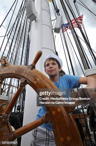 Charlestown - 070111 - U.S.S. Constitution - Tourist Peter Munyon 8, of Orlando, FL takes his turn at the helm of Old Ironsides wearing an official...