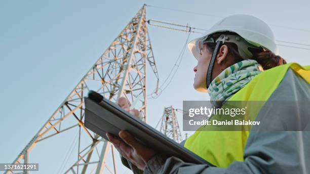 high voltage female engineer working on the field. - rede elétrica imagens e fotografias de stock