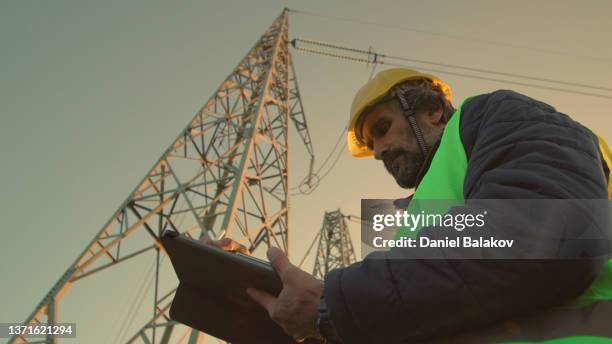 high voltage engineer working on the field at night. sustainable energy. - maintenance engineer stock pictures, royalty-free photos & images