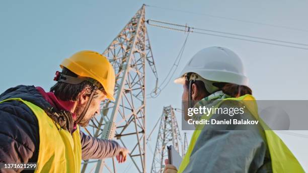 high voltage engineers working on the field. teamwork. - elnät bildbanksfoton och bilder