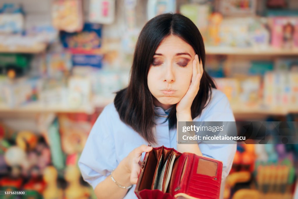 Worried Woman Checking her Wallet in a Store