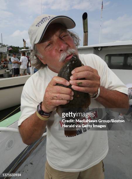 Army veteran David Goldstein from Belmont who fought in the Vietnam war kisses the flounder he caught while fishing with Harvey's Saltwater Fishing...