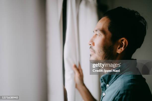 man looking outside from window - portrait profile view stock pictures, royalty-free photos & images