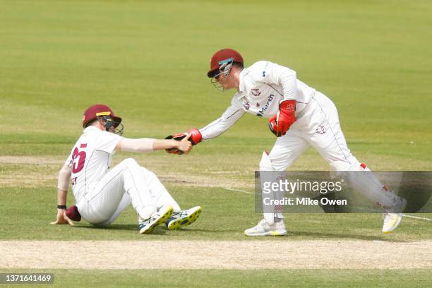 Bryce Street of Queensland is helped up by teammate Jimmy Peirson after being struck by the ball during day three of the Sheffield Shield match...