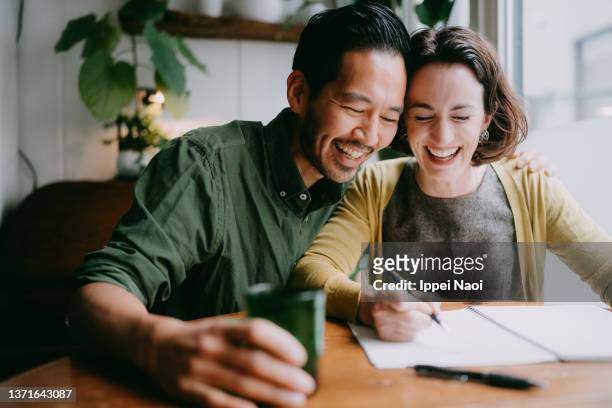 cheerful couple planning their future home - alegria fotografías e imágenes de stock