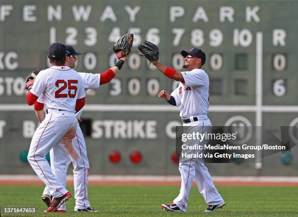 Boston Red Sox center fielder Jackie Bradley Jr., left fielder Daniel Nava and right fielder Shane Victorino celebrate a 6-0 victory over the Kansas...