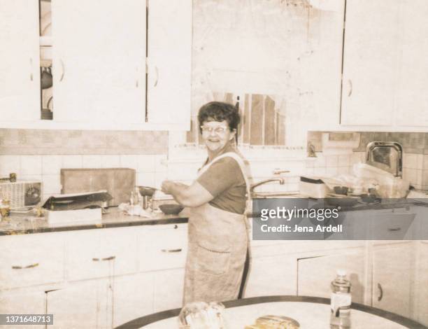 vintage grandmother in kitchen, vintage mother in kitchen, 1950s housewife - 1950s housewife stock-fotos und bilder