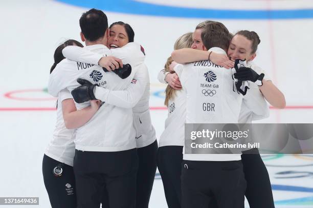 Team Great Britain celebrate with hugs after defeating Team Japan in the Women's Gold Medal match between Team Japan and Team Great Britain at...