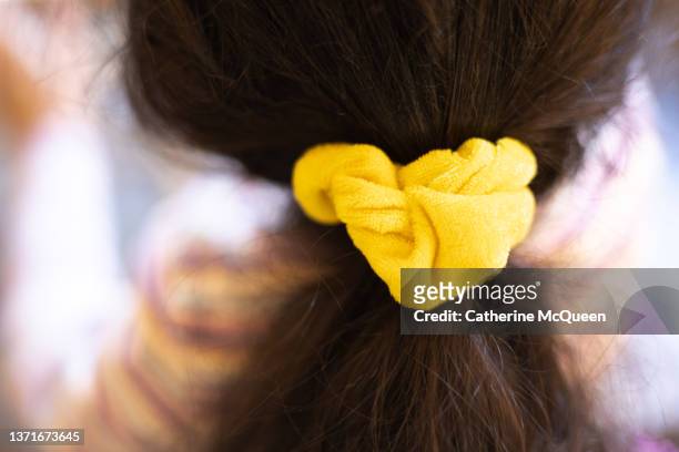 young mixed-race girl has hair pulled back in yellow hair scrunchie - hair bobble stock pictures, royalty-free photos & images