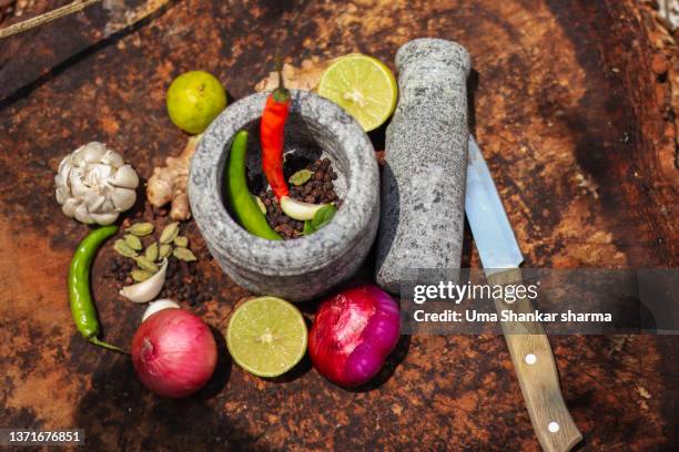 a traditional ayurvedic apothecary with stone mortar and pestle, herbs and spices. - crushed leaves stock-fotos und bilder