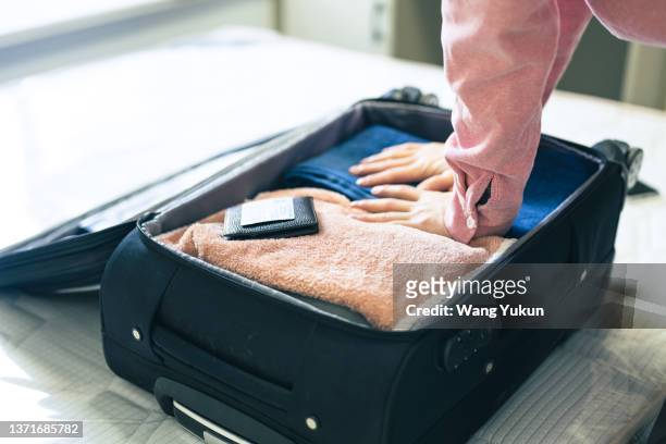 a young teenager is packing for a trip - suitcase packing stockfoto's en -beelden
