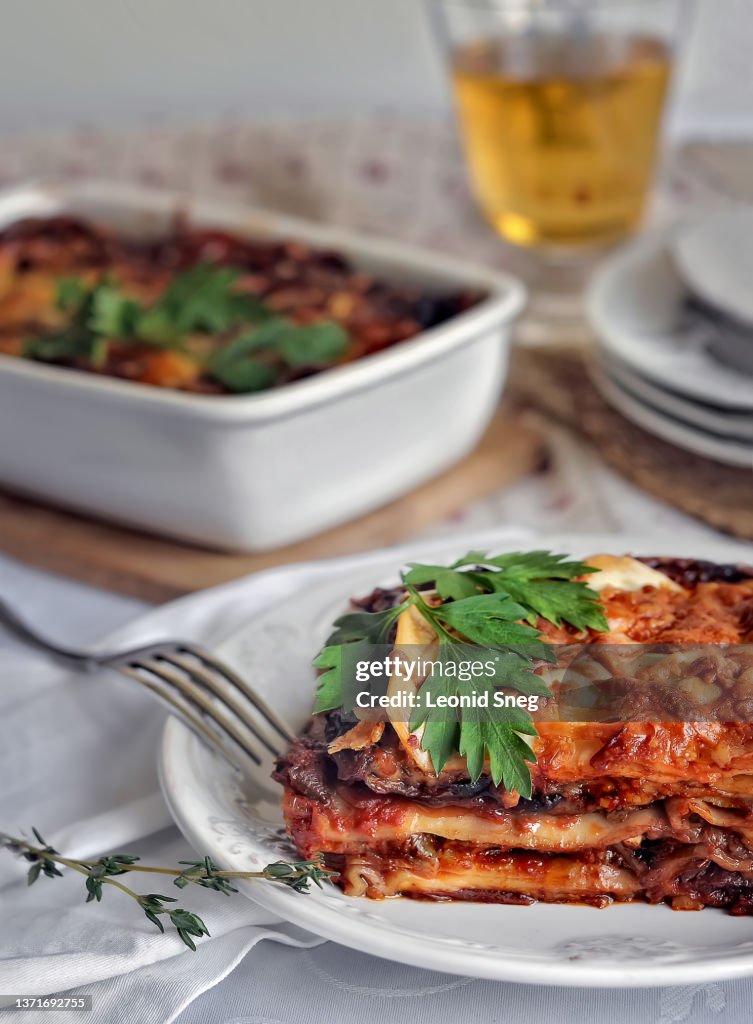 Meat lasagna with eggplant and tomato sauce on dinner table background
