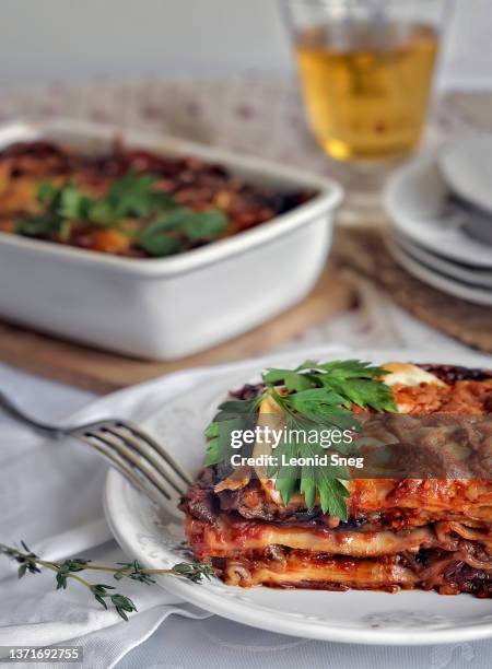 meat lasagna with eggplant and tomato sauce on dinner table background - serving lasagna stock pictures, royalty-free photos & images