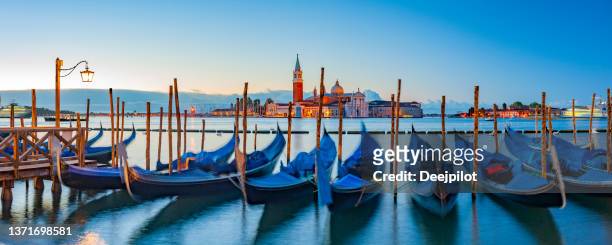 panoramic view of moored gondolas and san giorgio maggiore at sunrise in venice italy. - venetian bildbanksfoton och bilder