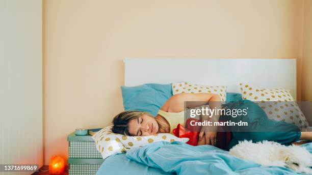 woman with stomach pain staying home - endometriosis stock pictures, royalty-free photos & images