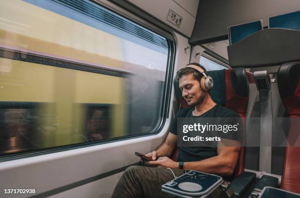 young man traveling in train - train leaving stock pictures, royalty-free photos & images