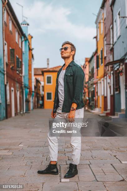 giovane turista che cammina per strada della città di burano, venezia, italia - burano foto e immagini stock