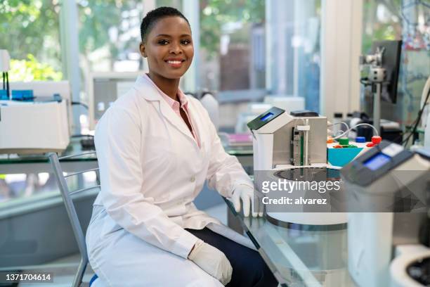 portrait of african female scientist working in laboratory - medical laboratory stock pictures, royalty-free photos & images