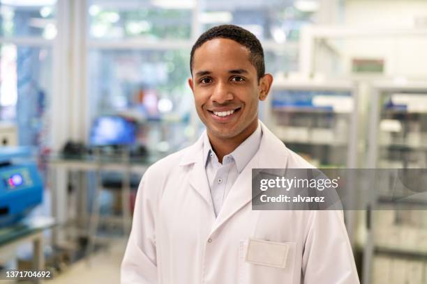 portrait d’un homme scientifique confiant debout dans un laboratoire médical - scientifique blouse blanche photos et images de collection