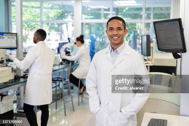 portrait of a medical researcher at a science laboratory - laboratoriumjas stockfoto's en -beelden