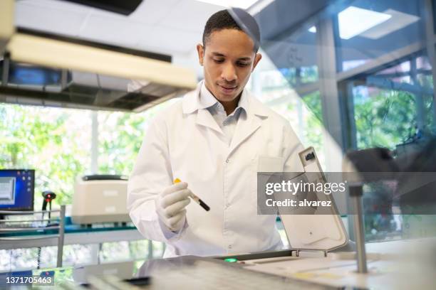 scientist examines blood samples in an analyzer machine in the laboratory - digital forensics stock pictures, royalty-free photos & images