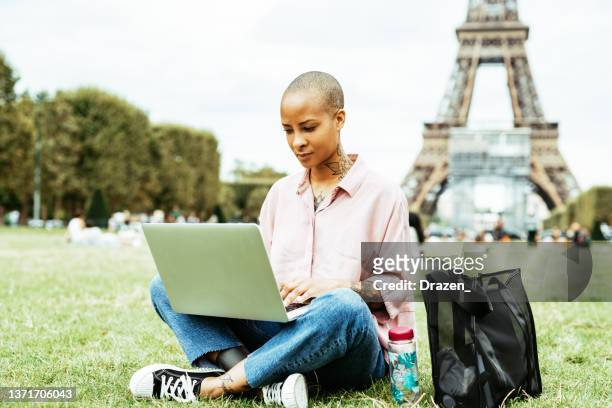 mixed race woman working on laptop outdoors. telecommuting and remote business meeting - african creative with laptop working outside stockfoto's en -beelden