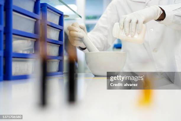 primo piano di uno scienziato che fa medicina in laboratorio - mortaio con pestello foto e immagini stock