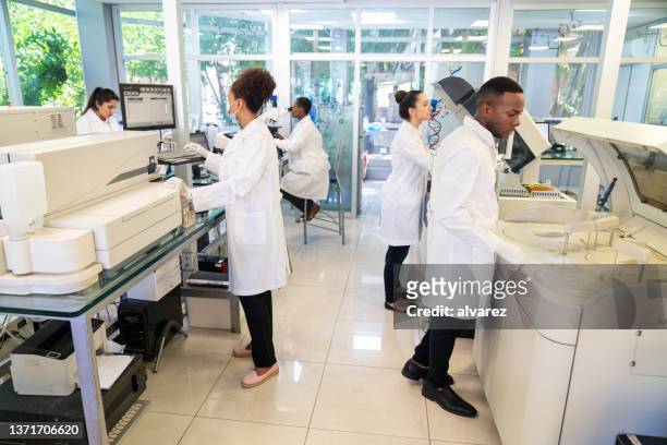 group of a scientists working in a research laboratory - bioquímica imagens e fotografias de stock