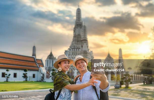 couple love romantic selfie at wat arun bangkok or arun temple which famous travel destination in thailand in travel trip during vacation for relaxation. lifestyle couple travel destination concept. - southeast asia stock-fotos und bilder