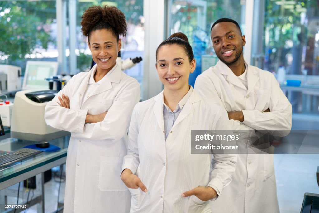Ritratto di tre scienziati in piedi insieme in laboratorio