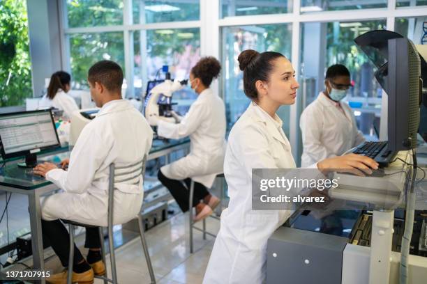 group of people working in a science laboratory - pathologist stock pictures, royalty-free photos & images