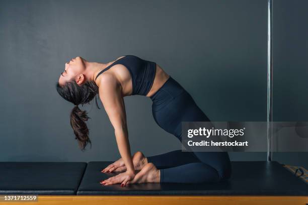 giovane donna che fa esercizi di pilates e yoga sulla macchina di pilates - metodo pilates foto e immagini stock