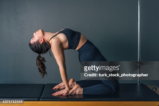 Young woman doing pilates and yoga exercise on pilates machine