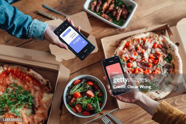 friends splitting bill via mobile payment on smart phone for food delivery - apple pay mobile payment stock-fotos und bilder