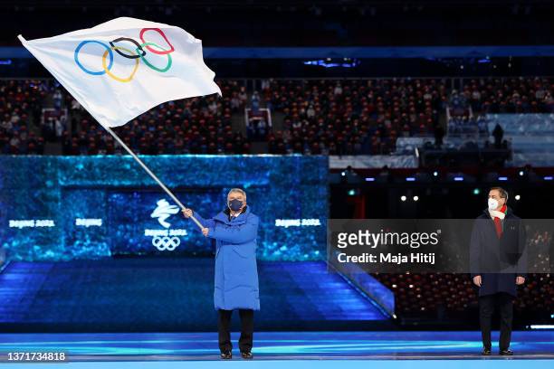 International Olympic Committee President Thomas Bach waves the Olympic flag during the Beijing 2022 Winter Olympics Closing Ceremony on Day 16 of...