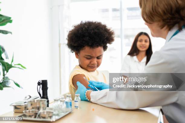 african american boy getting shot at hospital - receiving treatment concerned stock pictures, royalty-free photos & images