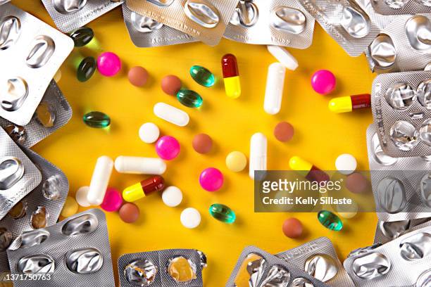 pills spilled with aluminum packages - medicare supplement stock pictures, royalty-free photos & images