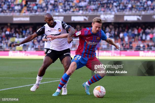 Frenkie de Jong of Barcelona is challenged by Dimitri Foulquier of Valencia during the LaLiga Santander match between Valencia CF and FC Barcelona at...