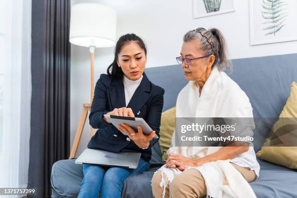 an insurance consultant visiting senior woman at home - seguro médico fotografías e imágenes de stock