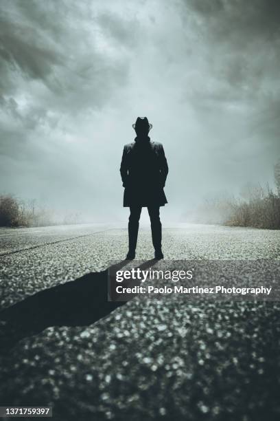 front view of silhouette gangster standing on road - organised crime stock-fotos und bilder