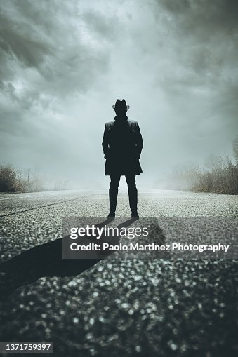 Front view of silhouette gangster standing on road Front view of silhouette gangster standing on road