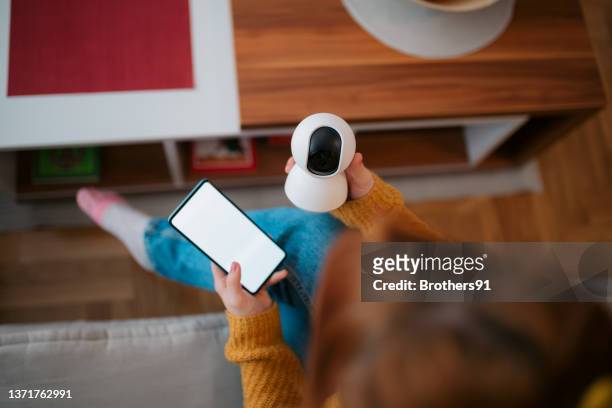 high angle view of an unrecognizable young caucasian woman operating home appliances at home remotely - security camera view stock pictures, royalty-free photos & images