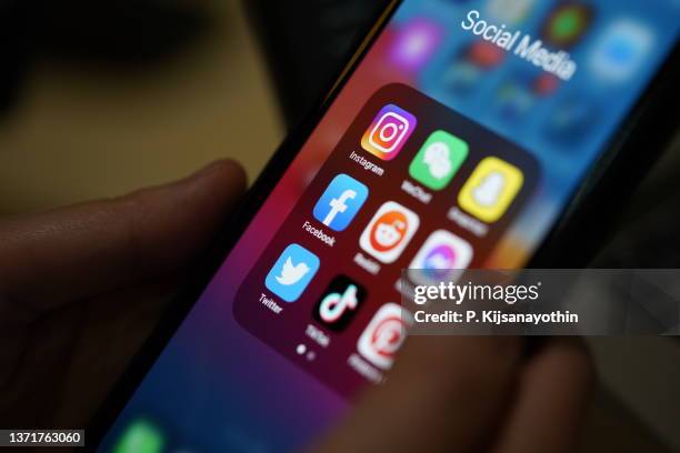 social media applications - using iphone imagens e fotografias de stock