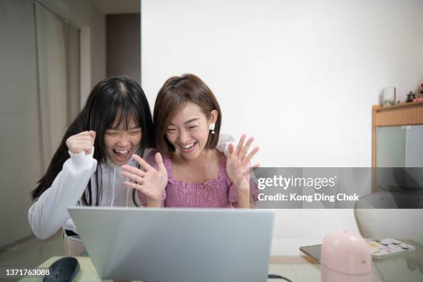 asian chinse mother share good news with daughter using laptop with smiling face at home. - pleased face laptop stock pictures, royalty-free photos & images