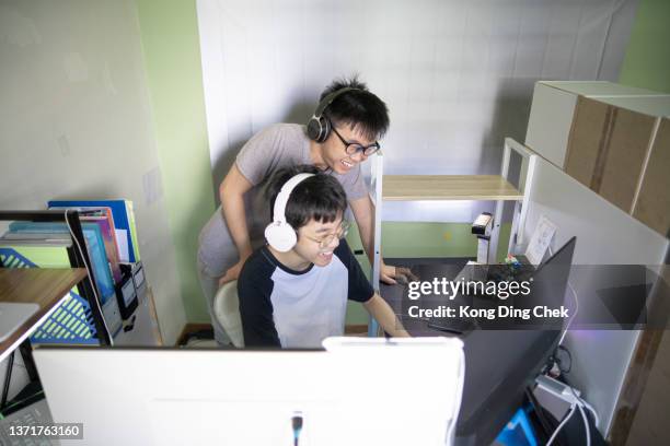 2 asian chinese sibling playing online game with smiling at home. - chinese teenage boy stockfoto's en -beelden